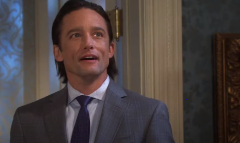 Jay Kenneth in a black suit poses a picture.